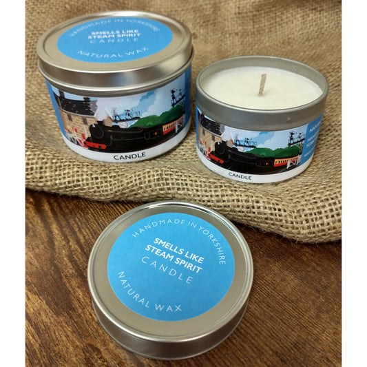 Two candles in metal tins, one with the lid off to show the white wax and wick.