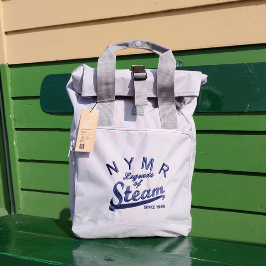 Grey backpack with 'NYMR Legends of Steam' text on a green platform bench