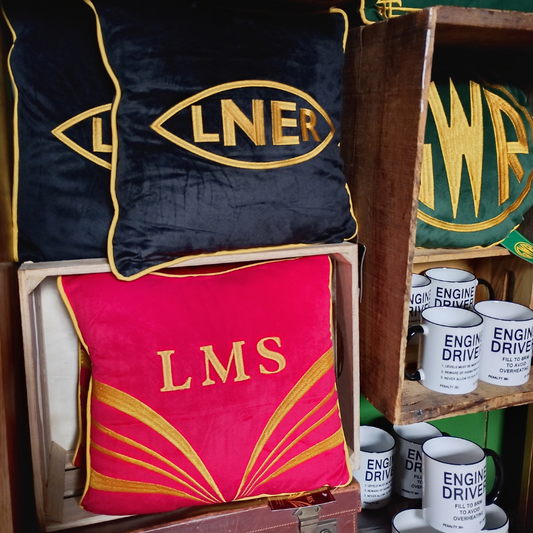 A number of different cushions in a shop setting.