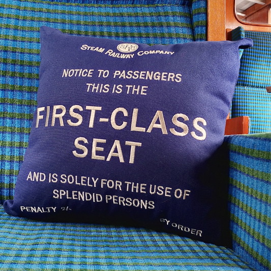 The blue First class cushion on a seat in a railway carriage