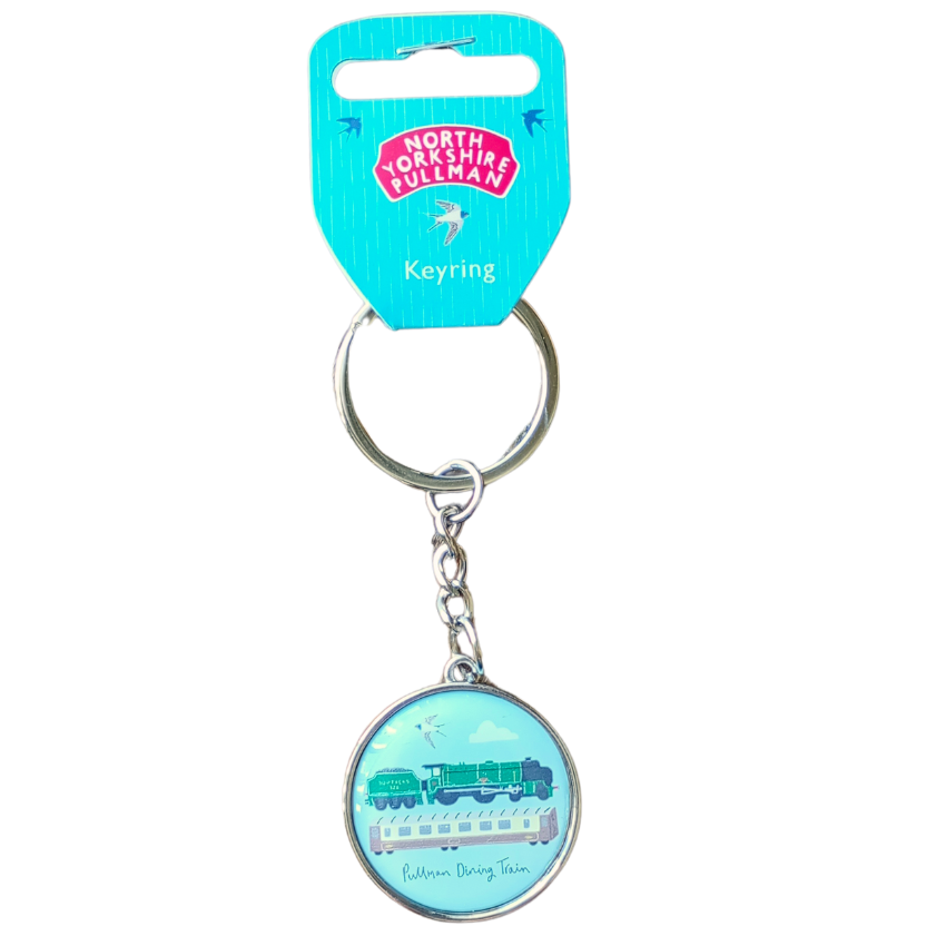A metal keyring with a resin charm featuring a train, part of the Jessica Hogarth collection. The charm is circular and has a blue background with a train illustration in the center.
