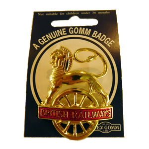 Gold coloured badge of lion over wheel with British Railways printed in gold on red background across middle of wheel. Presented on black card labelled A genuine Gomm badge.