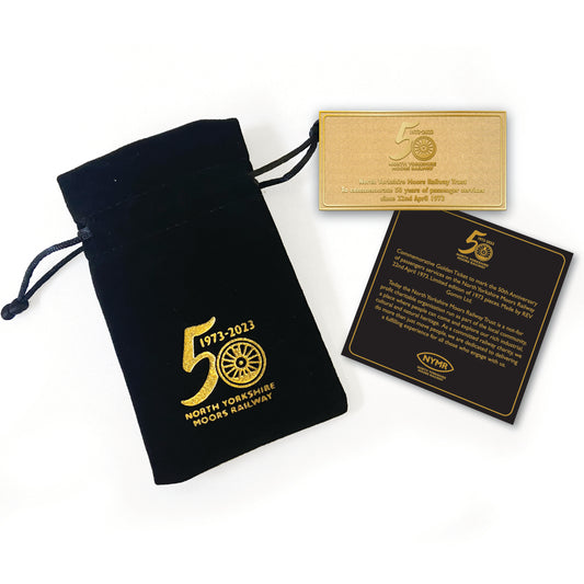 A golden metal ticket with black velvet pull string pouch and information card in matching colours