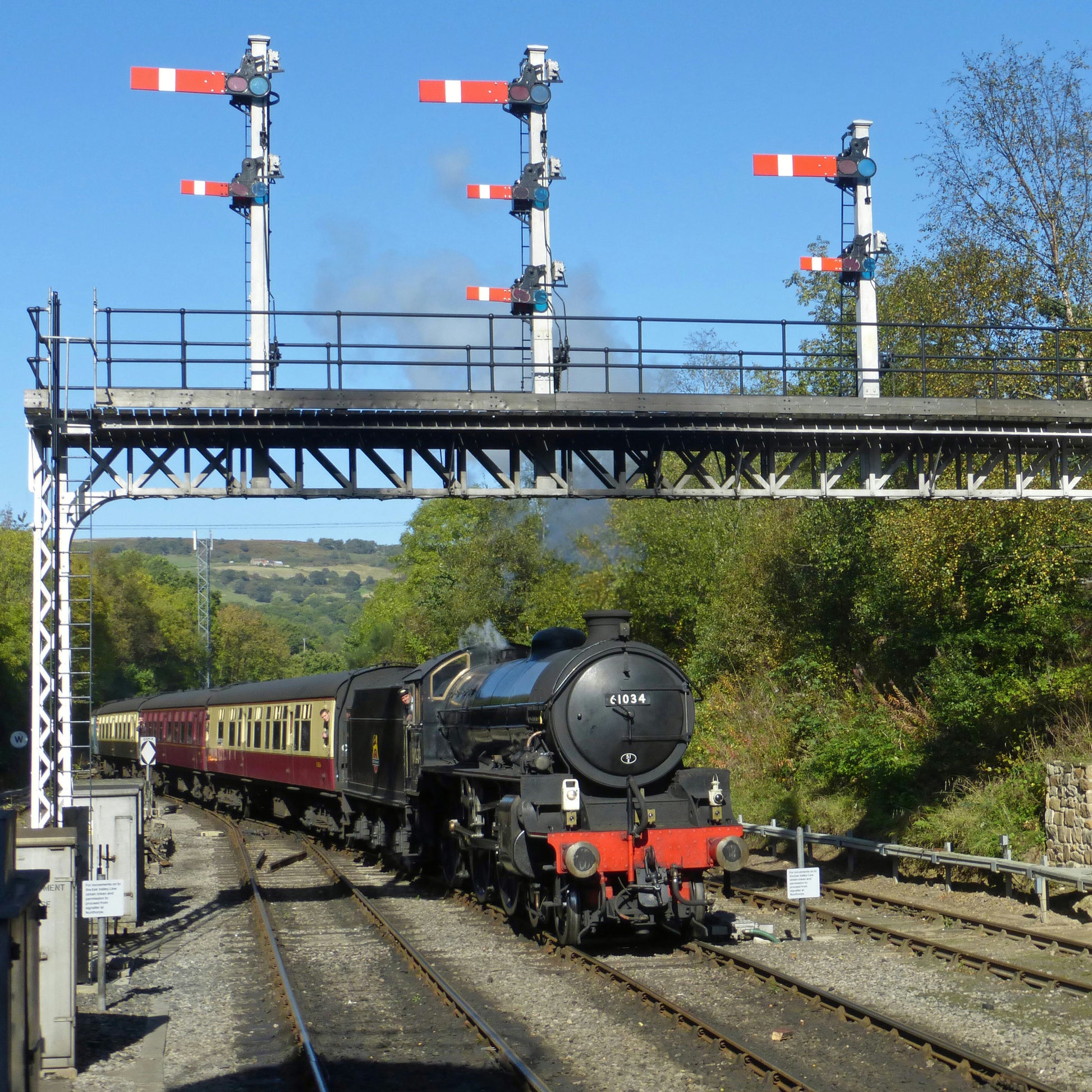 Locomotive 61264 arriving at Grosmont and passing beneath the signal gantry showing the signal arms in position.