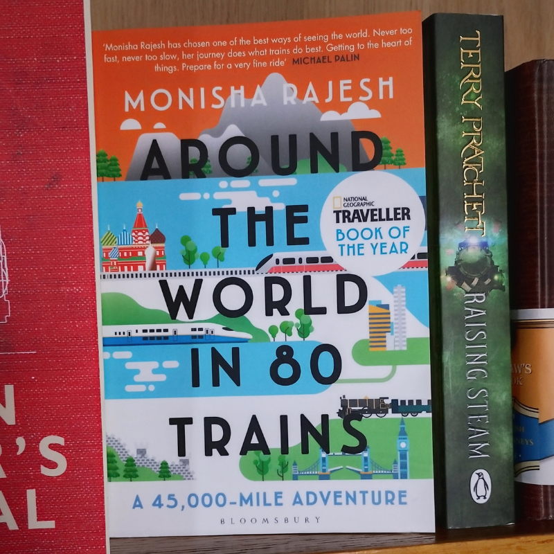 Book on shelf showing title and graphic design with landmarks and trains.