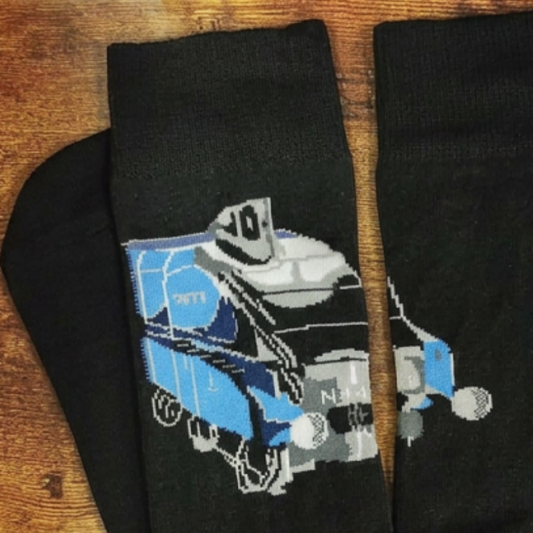A pair of black crew socks laid flat on a wooden surface, featuring a pixelated graphic of a blue A4 locomotive.