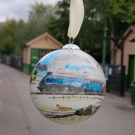 Round glass bauble showing handpainted design of Sir Nigel Gresley and a fox crossing the snowy moors