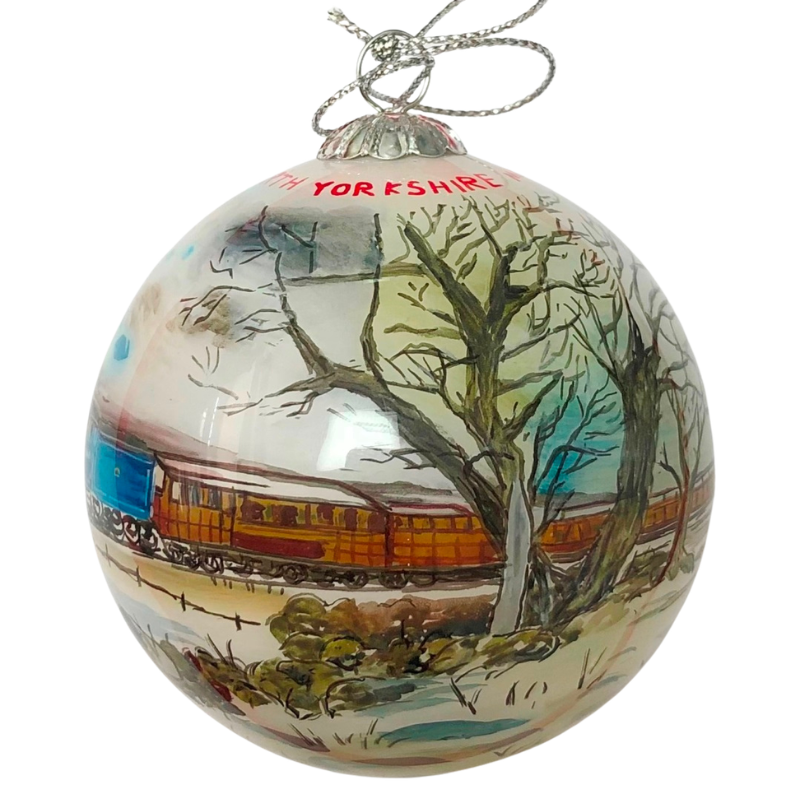 Side detail of bauble with teak carriages and a tree.