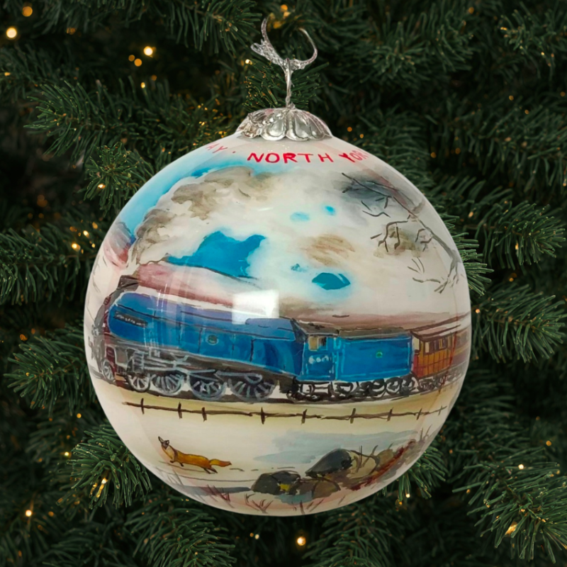Glass bauble with hand painted design of locomotive 60007 Sir Nigel Gresley steaming across the moors.