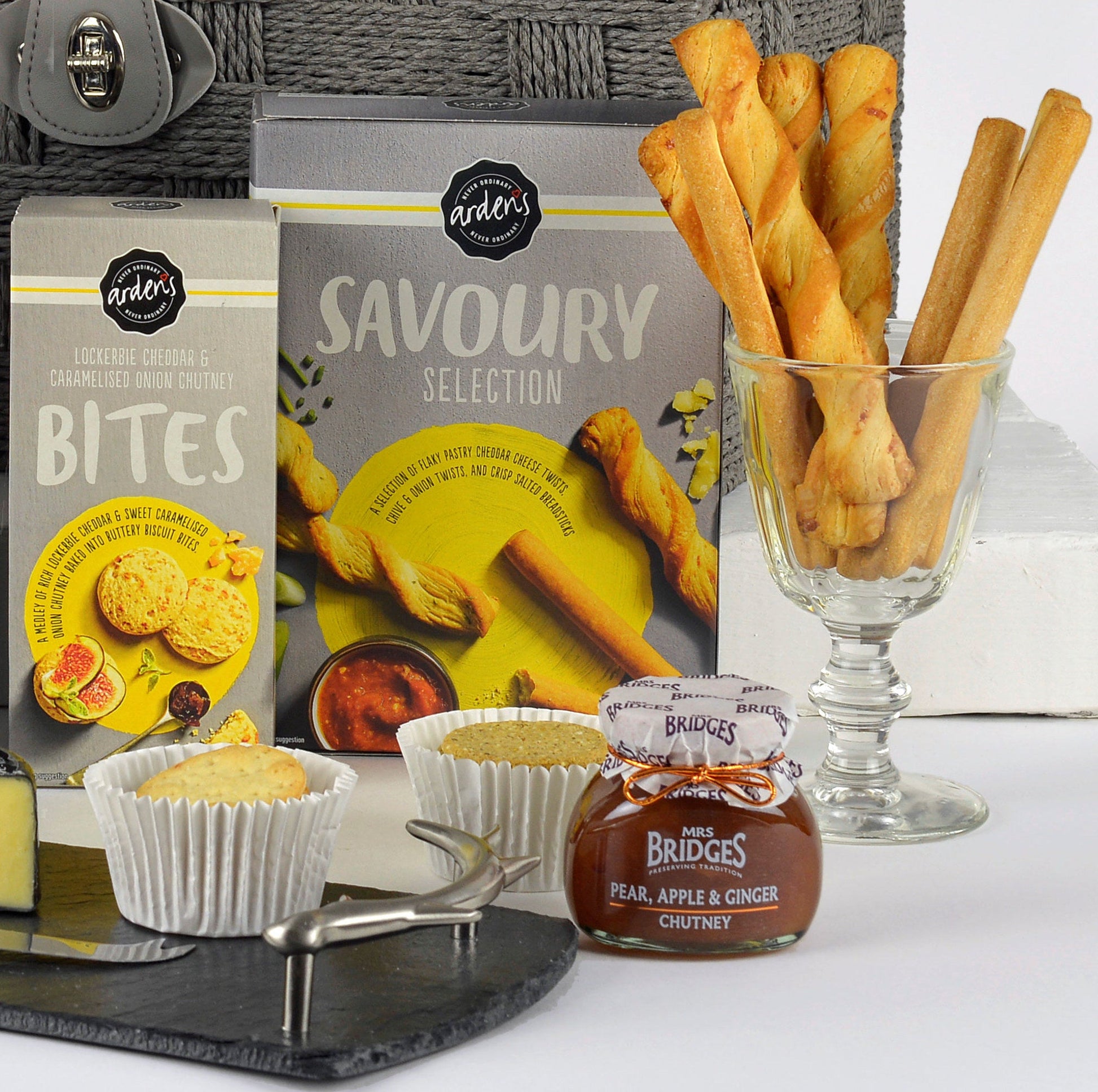 Assorted food items including savoury selection, muffins, and chutney on a white surface.