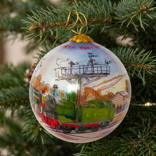 Round glass bauble with hand painted design showing two locomotives at Grosmont Station with the words NORTH YORKSHIRE MOORS RAILWAY around the top.