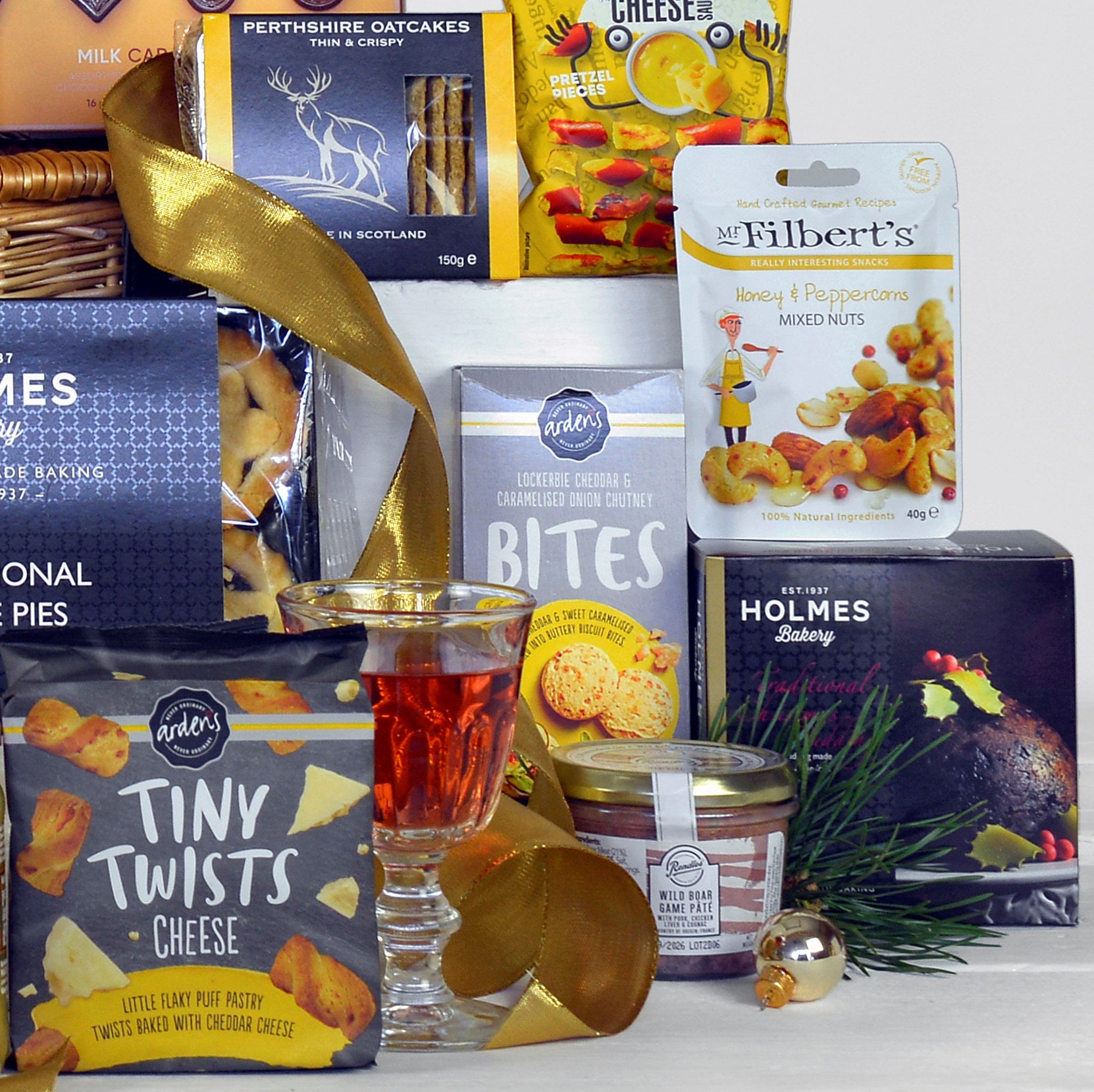 Assorted food products including cheese, crackers, and a glass of rose wine on a white surface.