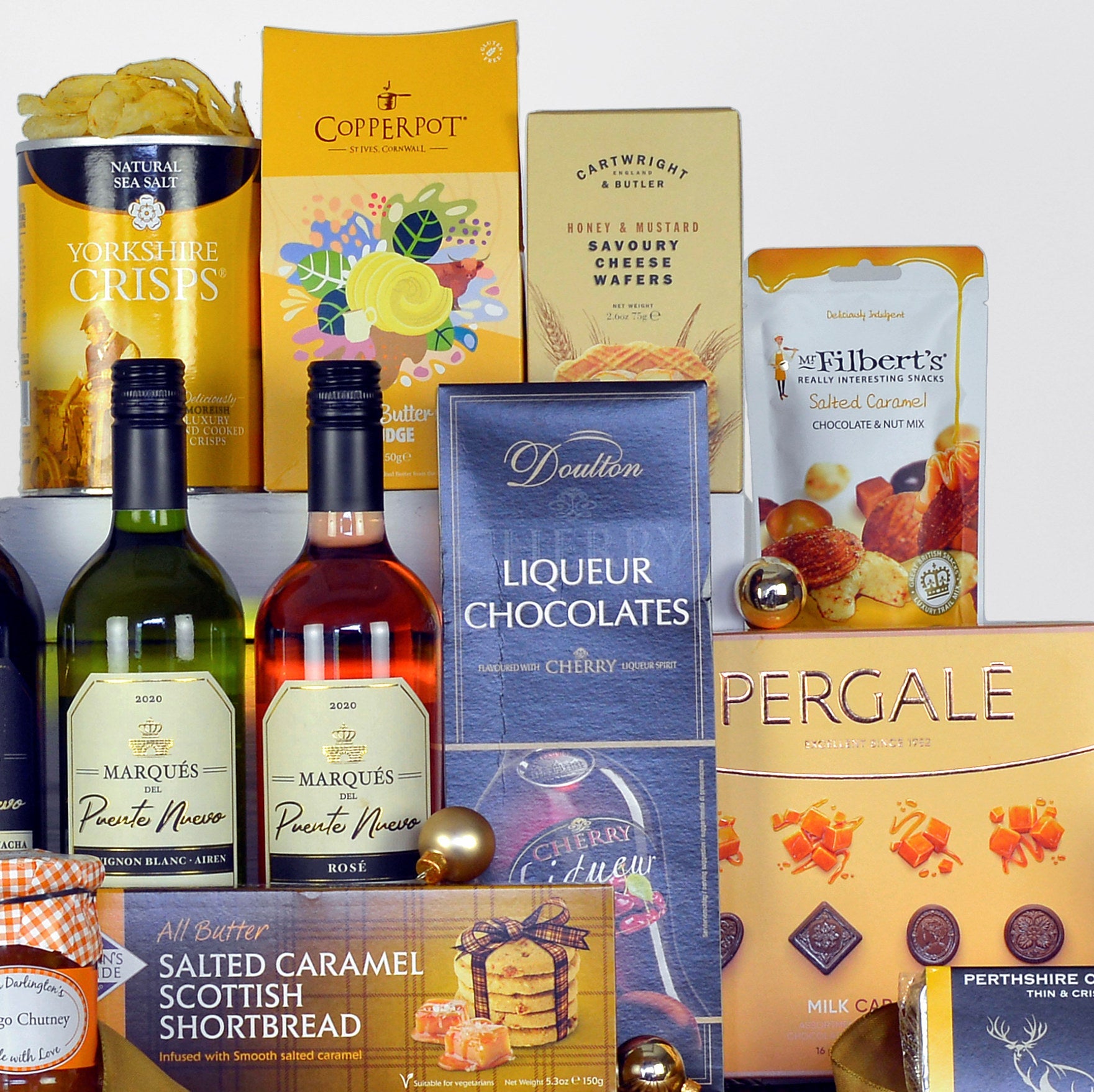 Assorted gourmet products including bottles of wine, boxes of fudge, chocolates and shortbread on a white background