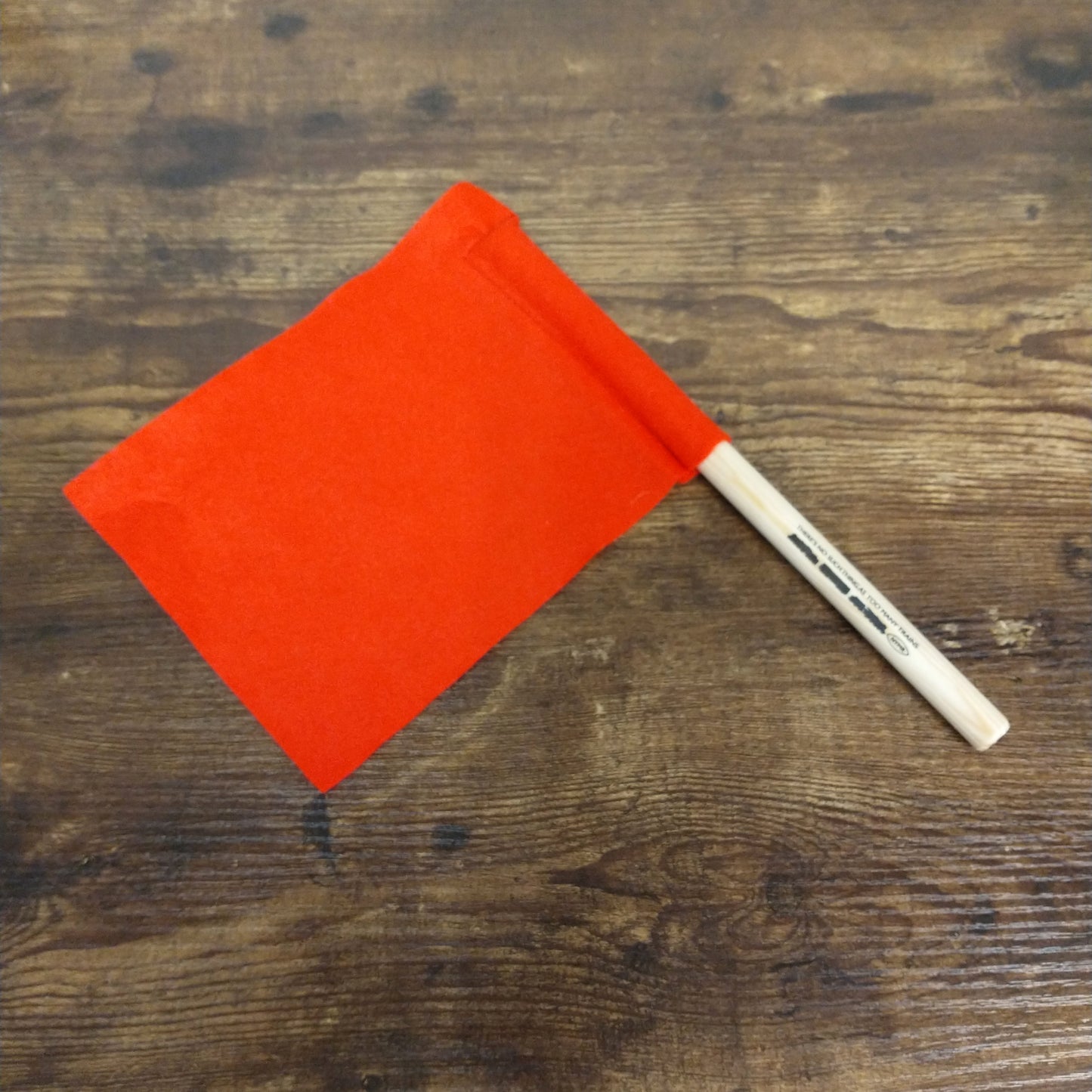 A red felt flag with a wooden stick