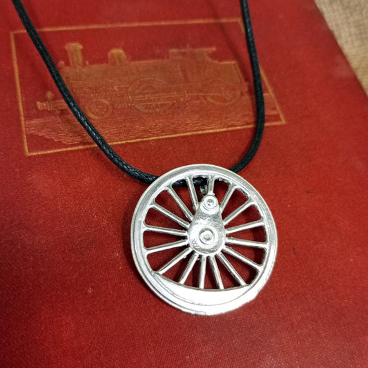 Pewter pendant in the wheel design on the cover of a vintage book to add a bit of glamour