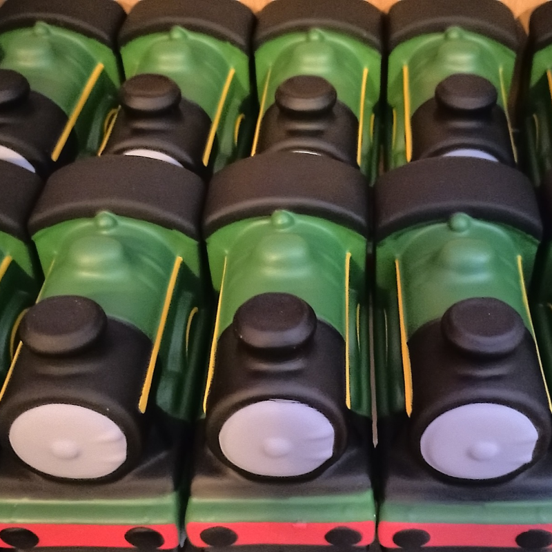Lines of green squishi locomotives in rows