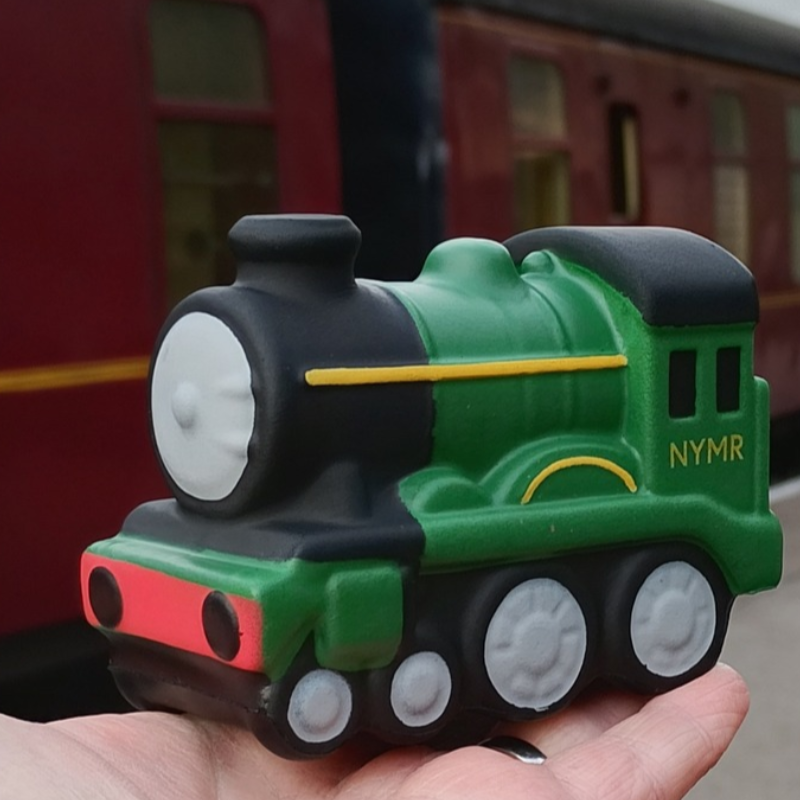 A dinky soft edged green locomotive sat on the palm of a hand
