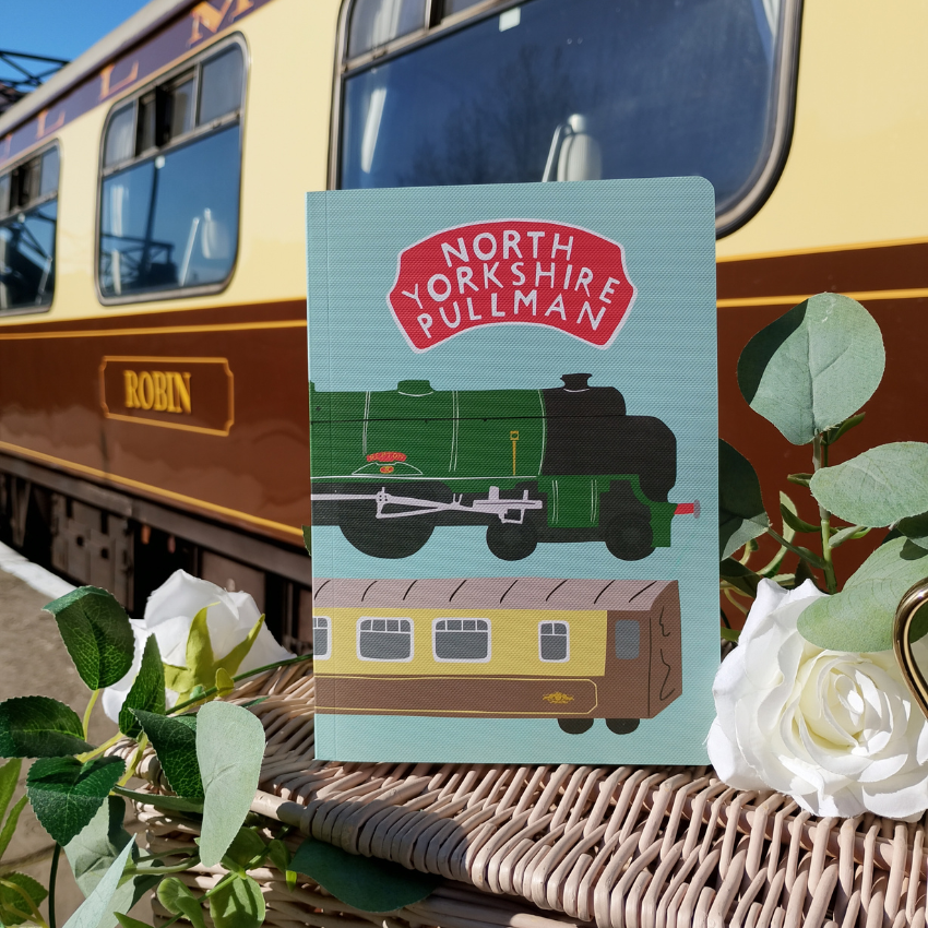 Notebook with North Yorkshire Pullman design in front of a train