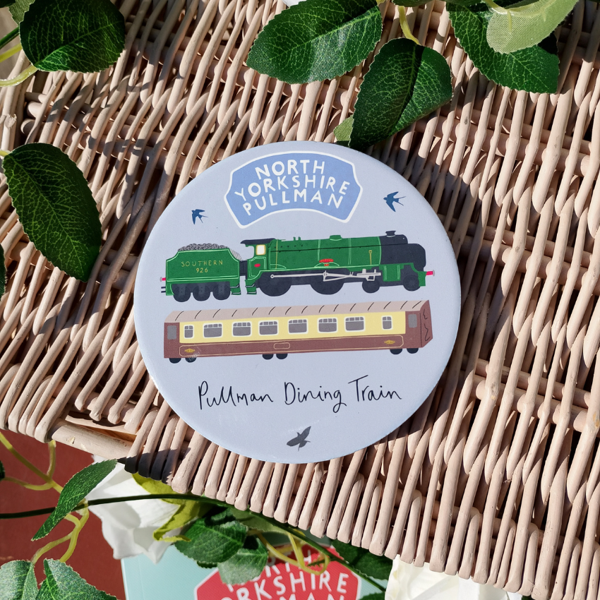 Coaster with train design and 'North Yorkshire Pullman' text on a woven surface with leaves.