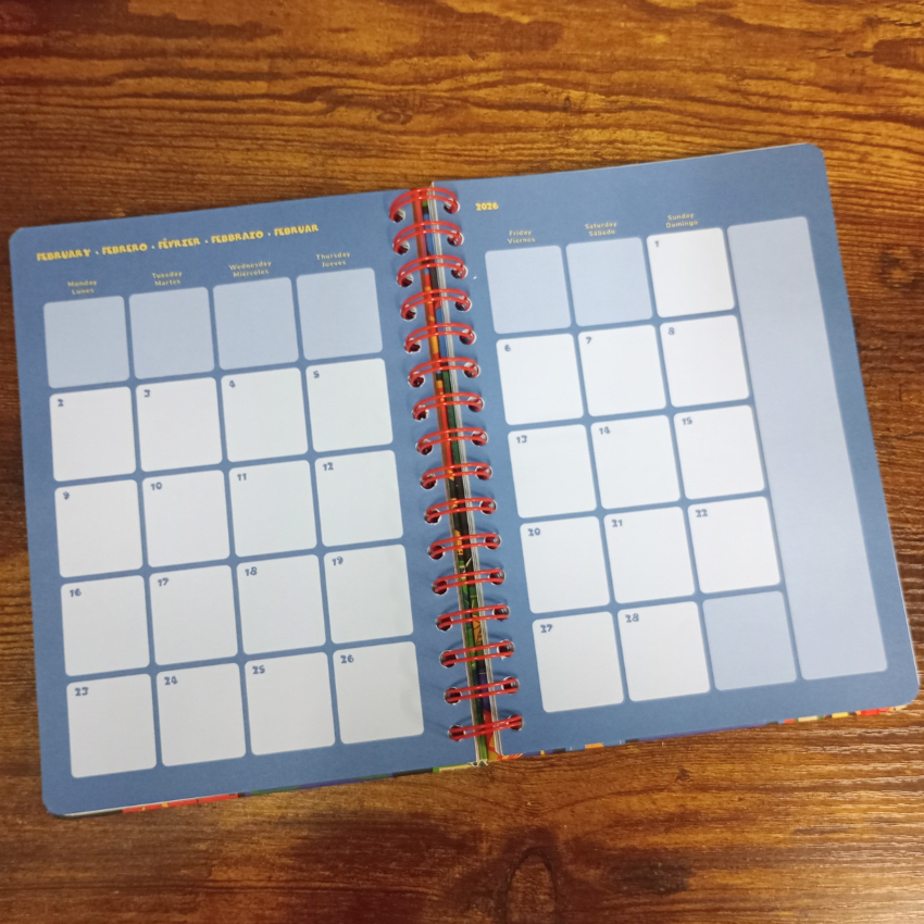 Open planner with calendar pages on a wooden surface