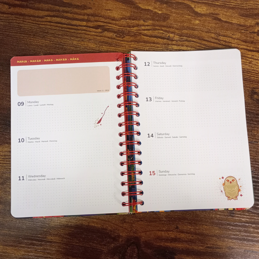 Open spiral-bound planner on a wooden surface