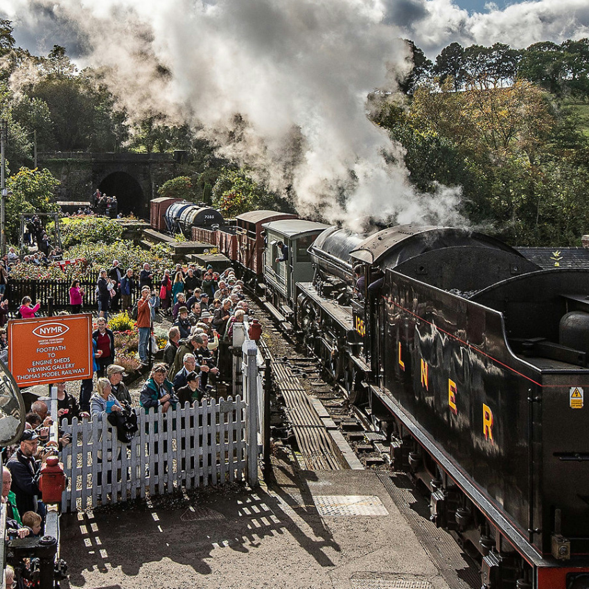 Steam train passing over Bridge 42 at Grosmont  surrounded by spectators.
