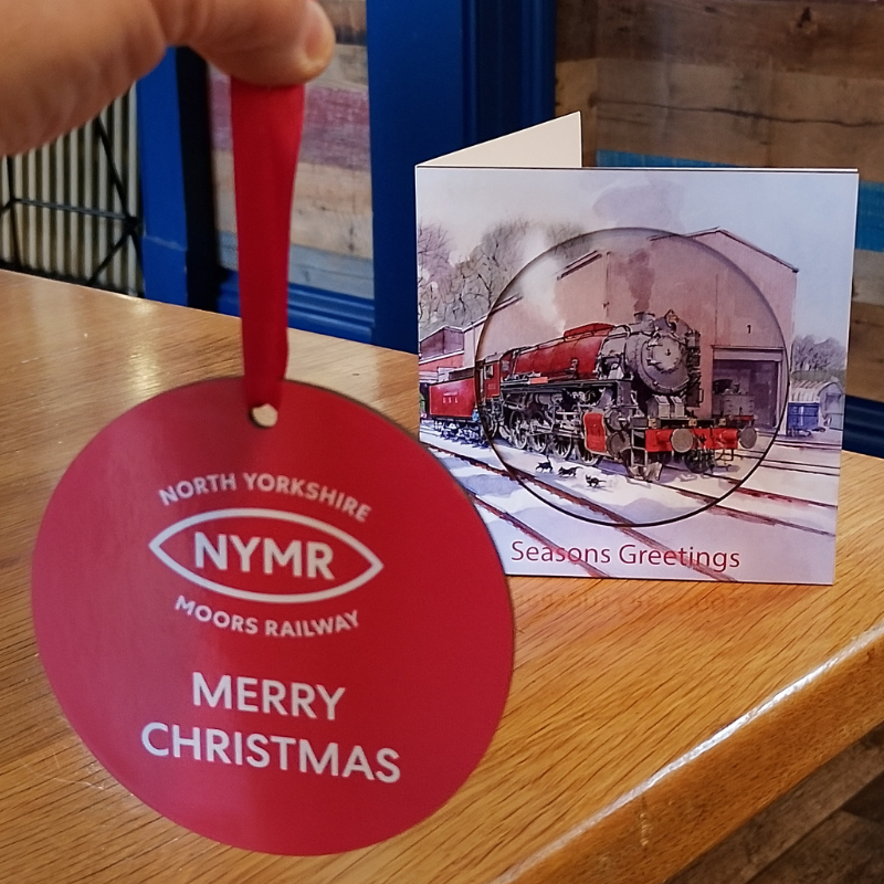 Image showing the reverse of the tree decoration which has the NYMR logo and MERRY CHRISTMAS in white text printed on a red background