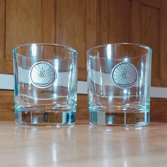 Two whisky tumblers each with a wheel cast in pewter on the front. No whisky though, shame.