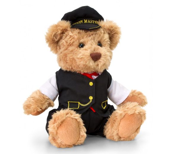 Gold coloured teddy bear in black suit wearing black cap with Station Master written on peak.