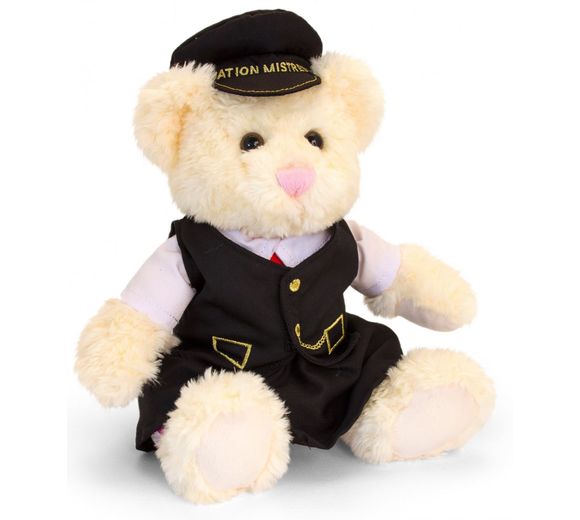 Cream coloured teddy bear in black suit wearing black cap with Station Mistress written on peak