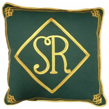 Square green cushion with gold piping and design round edge and S R in diamond embroidered in gold in centre