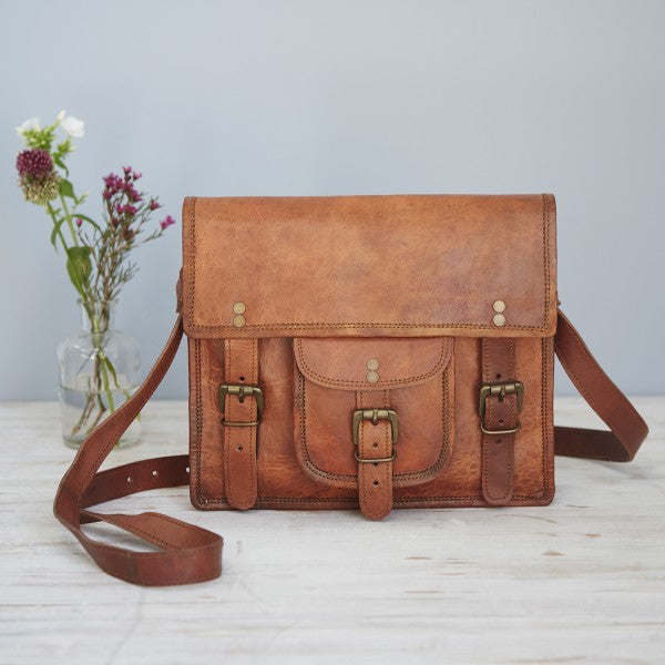 Large tan leather shoulder bag with separate buckled pocket on front and flap with two buckle fastenings.