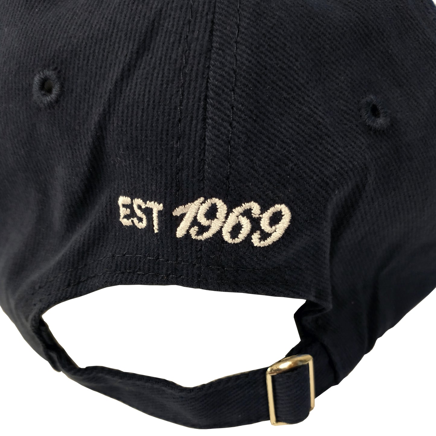 Close up of established 1969 embroidered in white on back of baseball cap above adjustment.