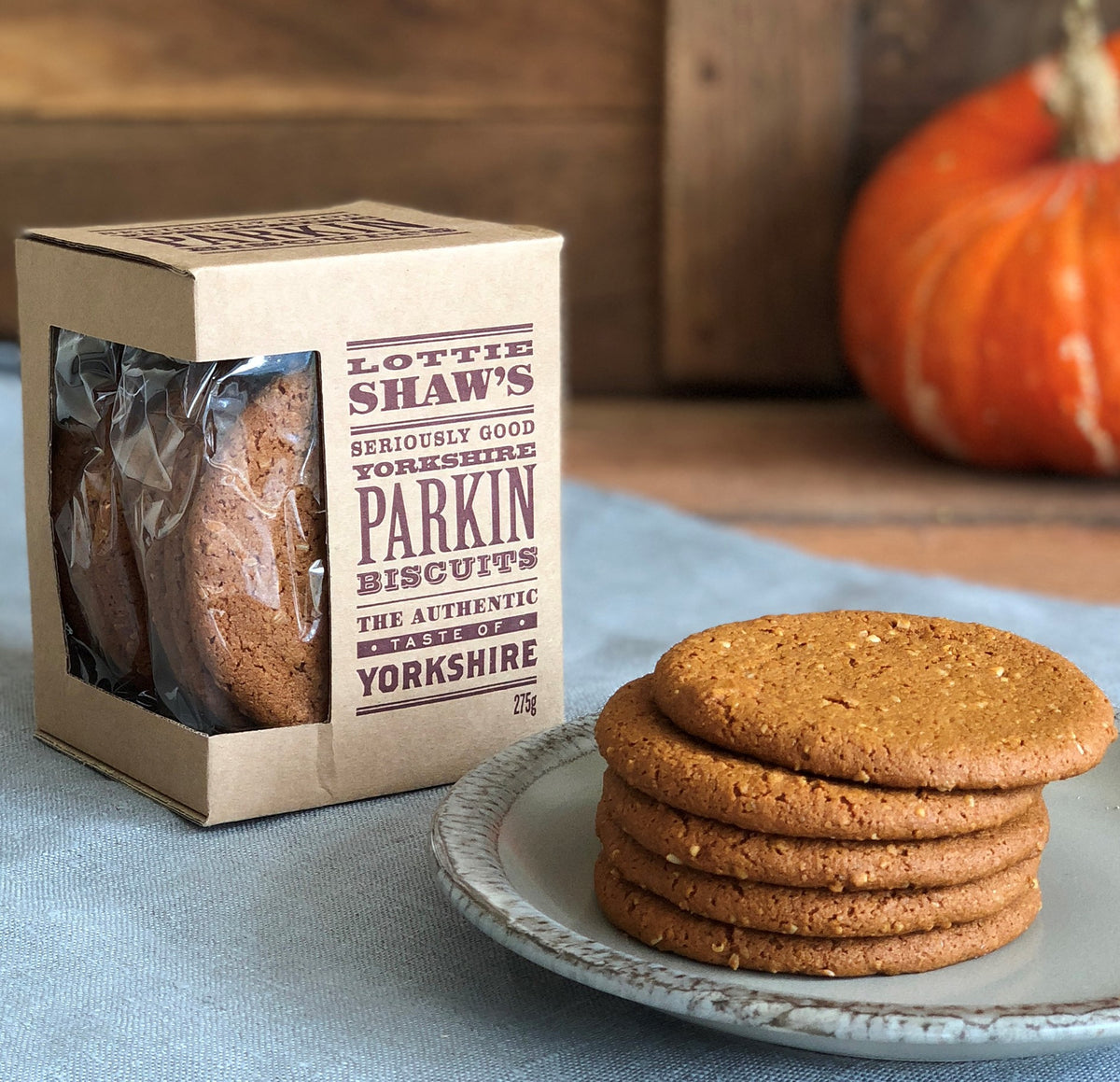 Box of Lottie Shaw's Yorkshire parkin biscuits with the contents showing through a cellophane window.  Some biscuits are shown on a plate.