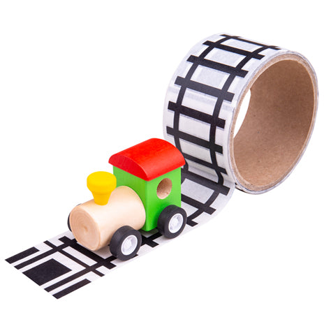 A wooden steam engine sat on a track made from printed tape. The tape is stuck to the floor and is also shown on the tape roll.