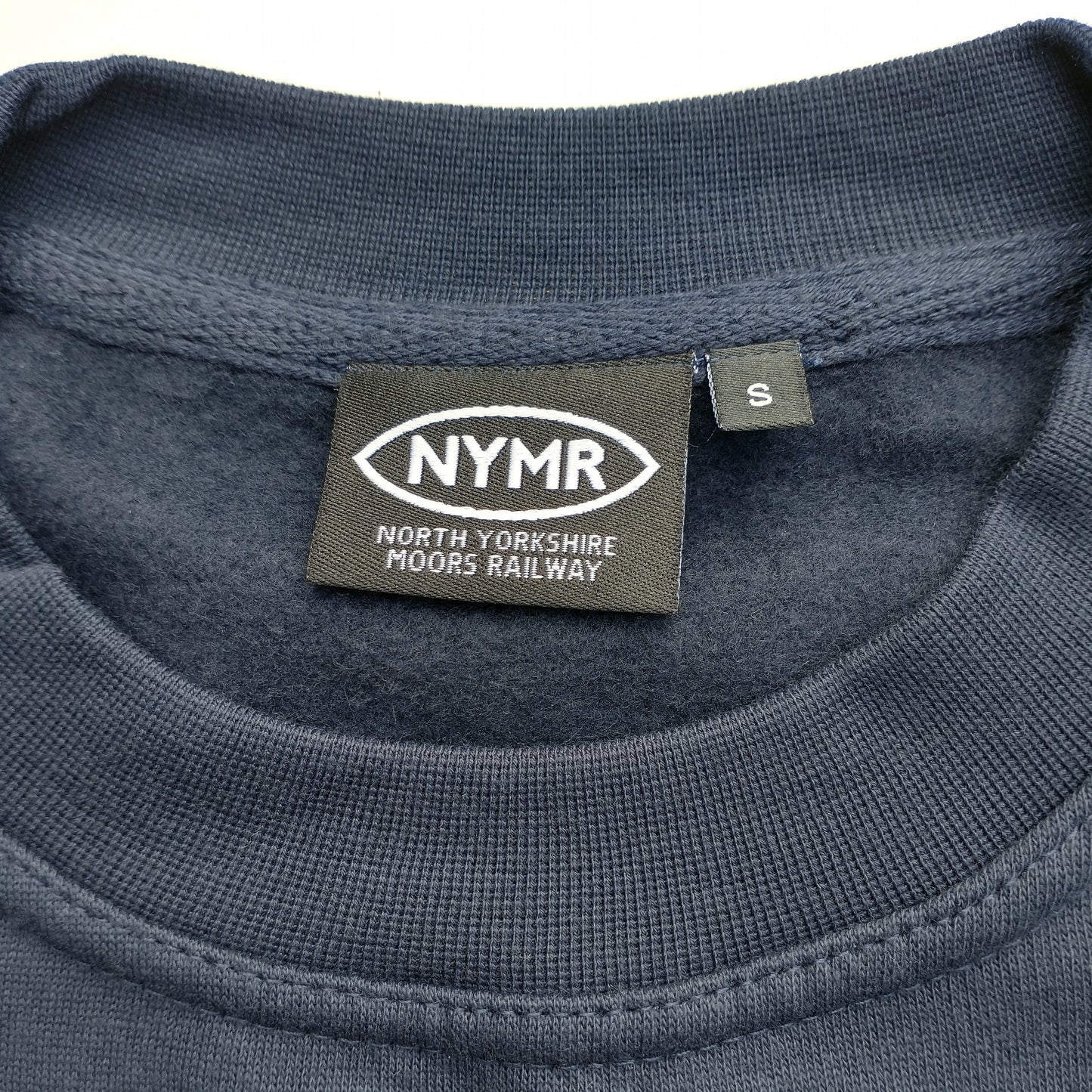 Close up of neck of sweatshirt with NYMR label
