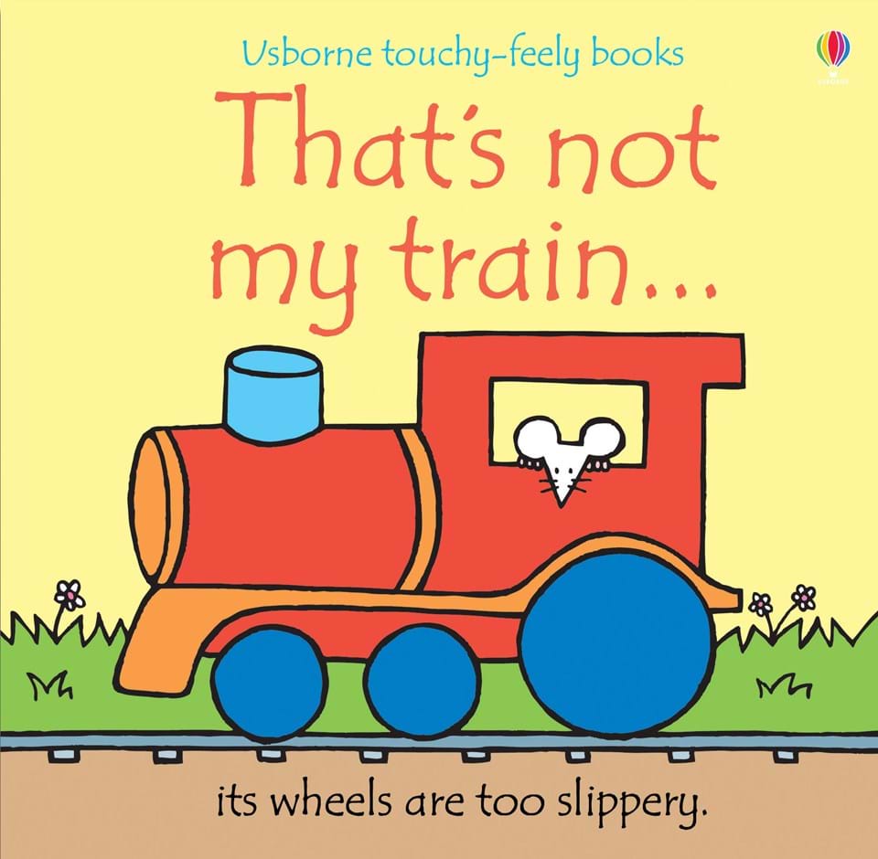 Yellow front cover of child's book with cartoon picture of red, yellow and blue steam engine with white mouse driver. That's not my train ... printed in red at the top with its wheels are too slippery in black under the train.